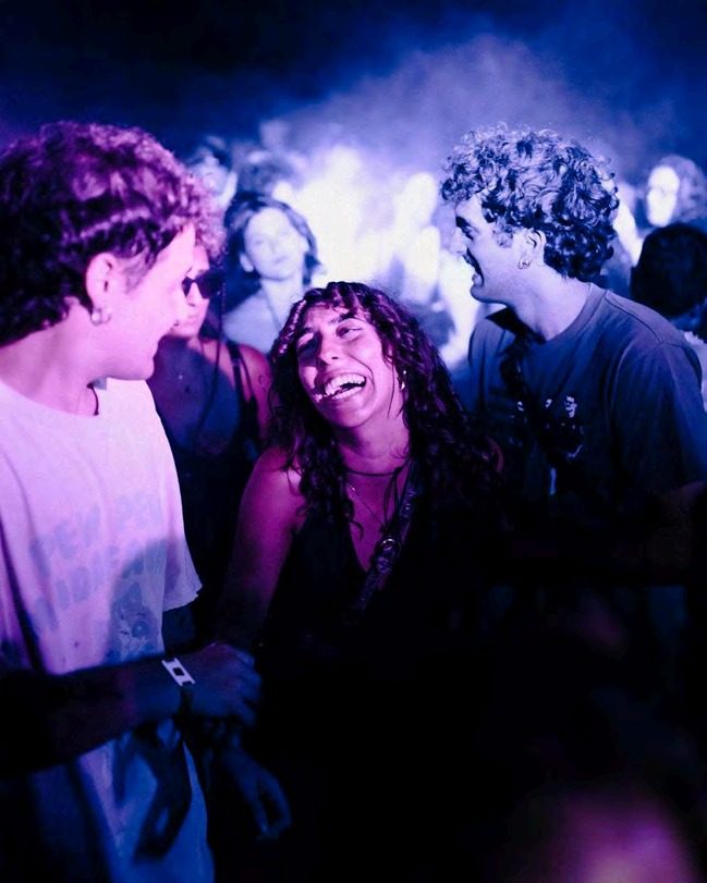 Crowd dancing under purple lights at Mosaico Festival