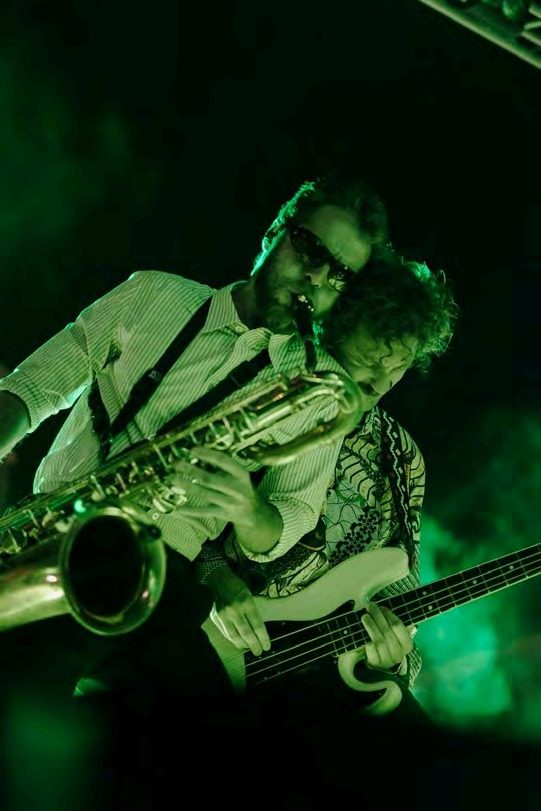 Saxophonist performing in green stage light