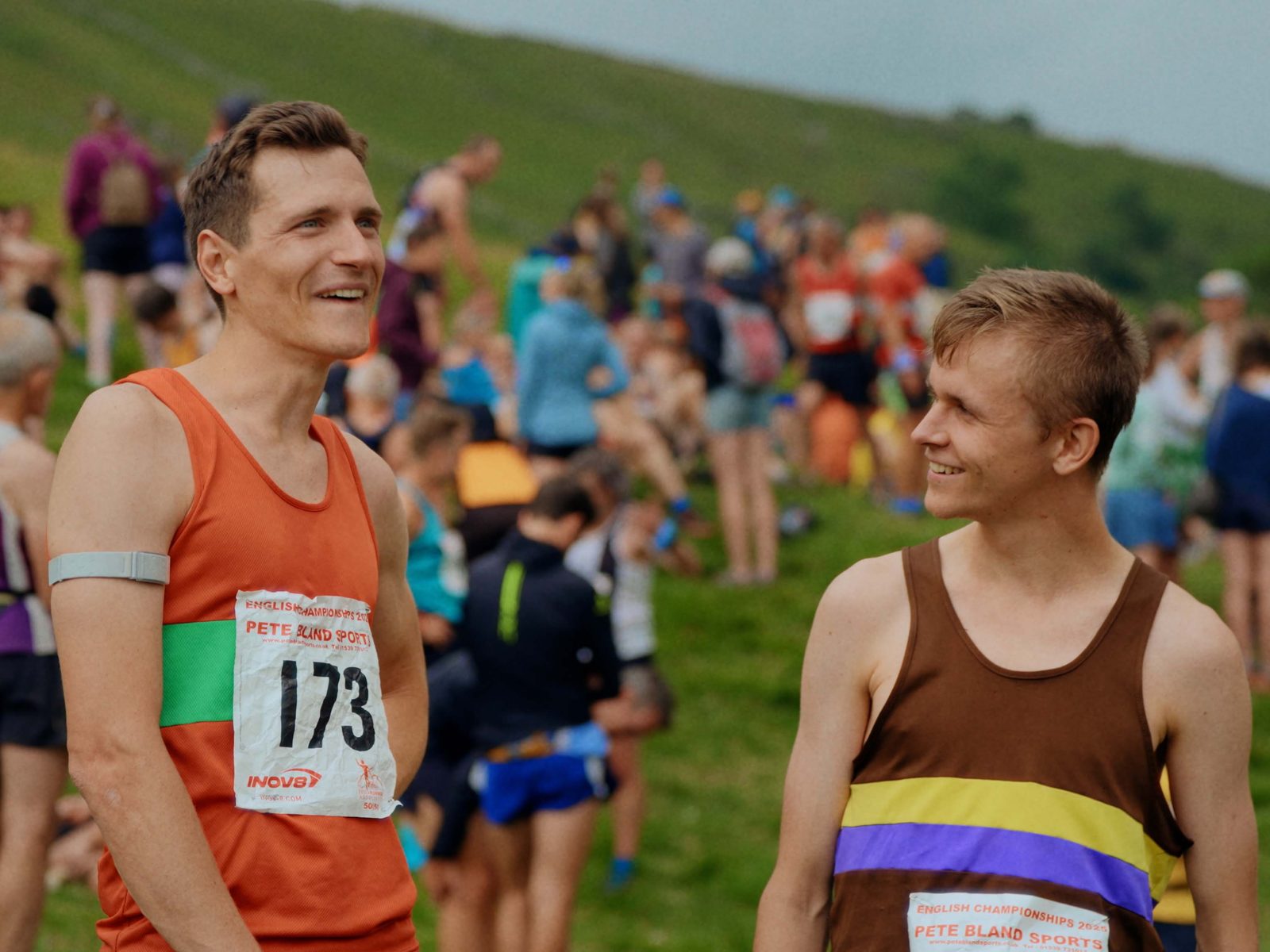 Two fell runners laughing together at a race start in the Yorkshire hills