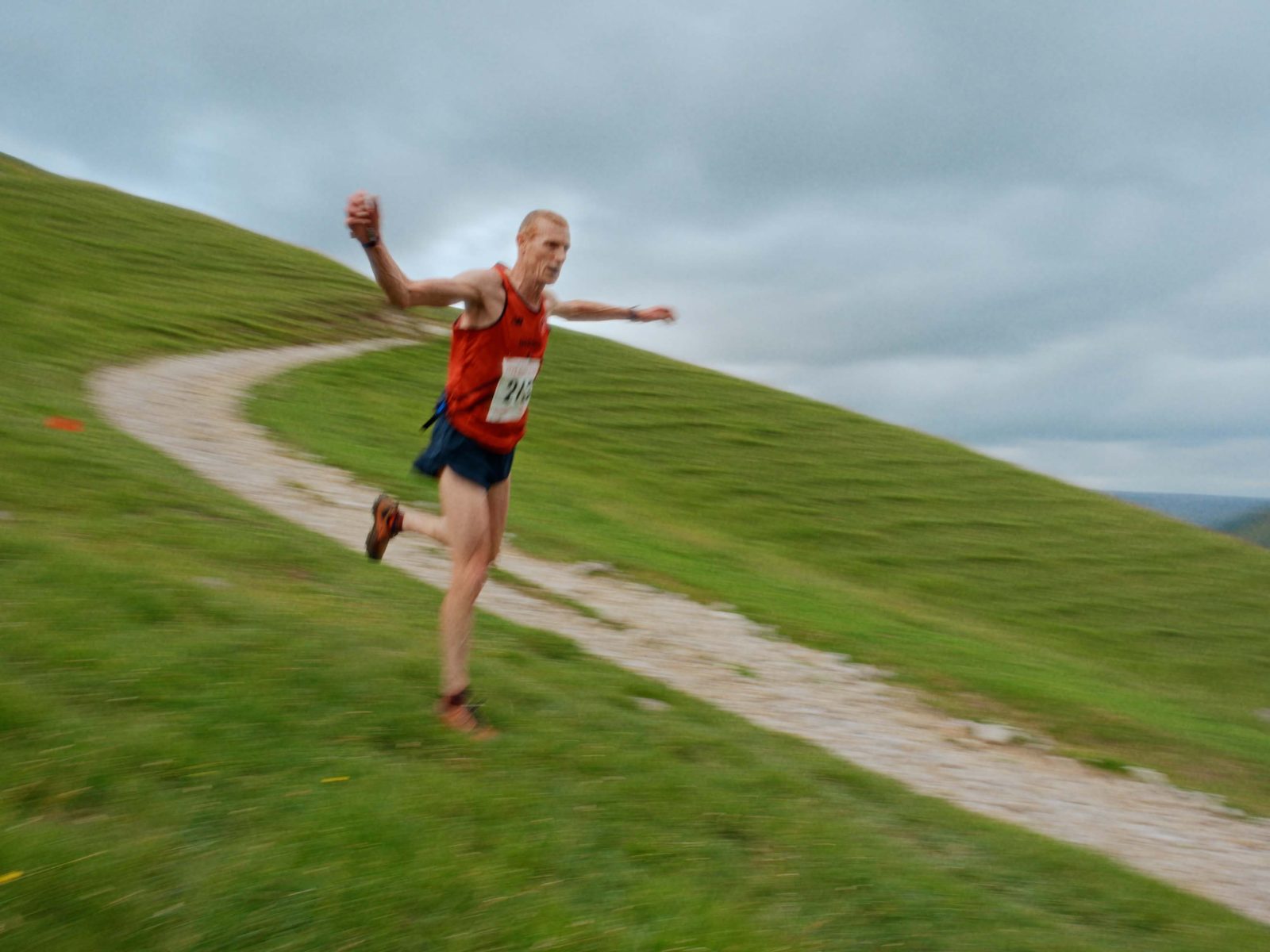 A fell runner sprinting downhill at full speed