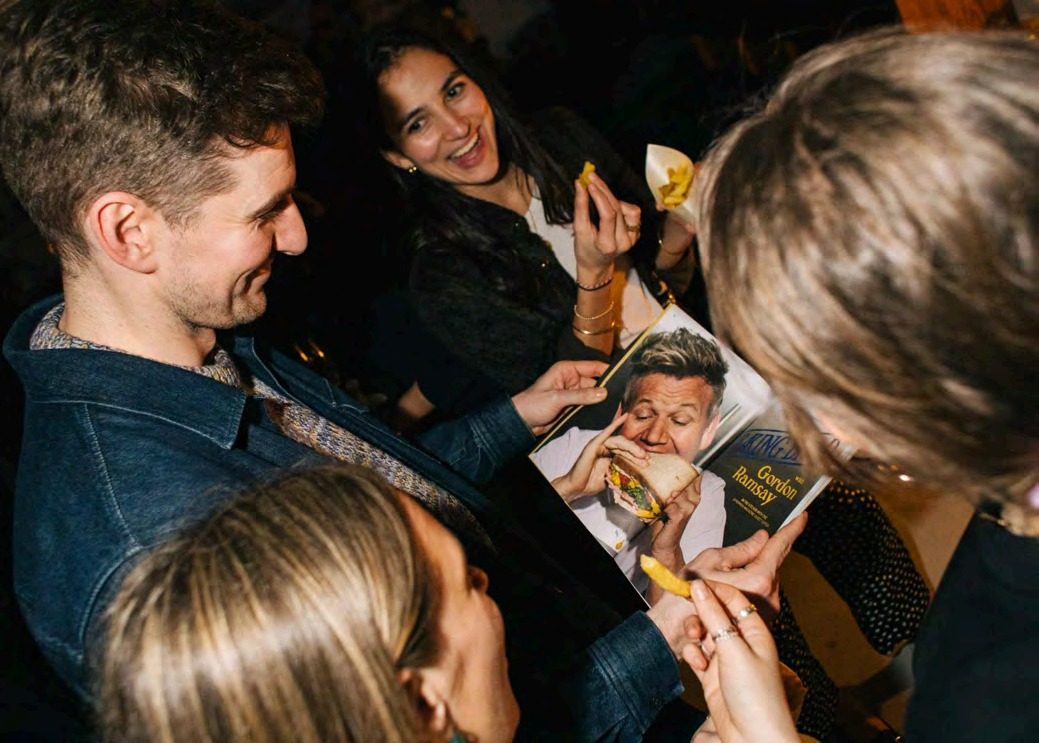 Guests signing magazine covers at the party