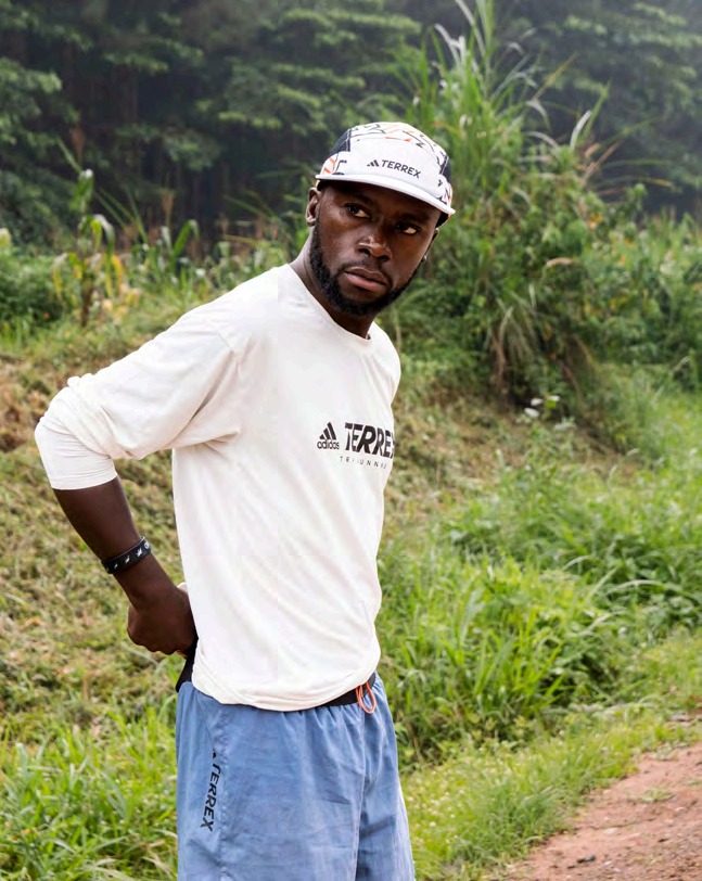 Deo Kato standing on a red dirt road in Uganda