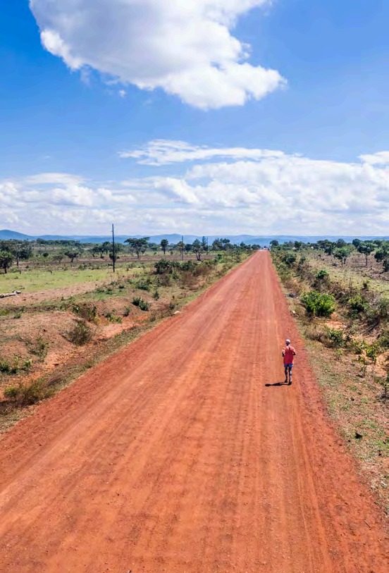 A long red dirt road stretching to the horizon